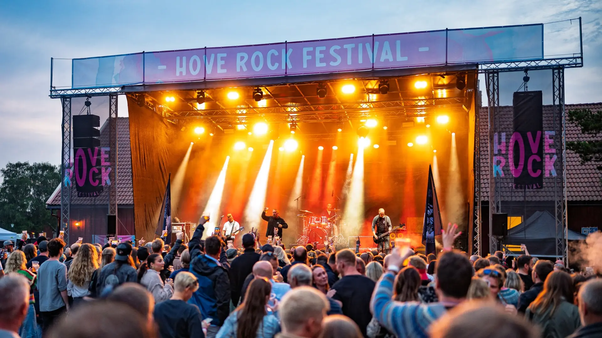 Publikum foran scenen under en norsk festival i skumringen